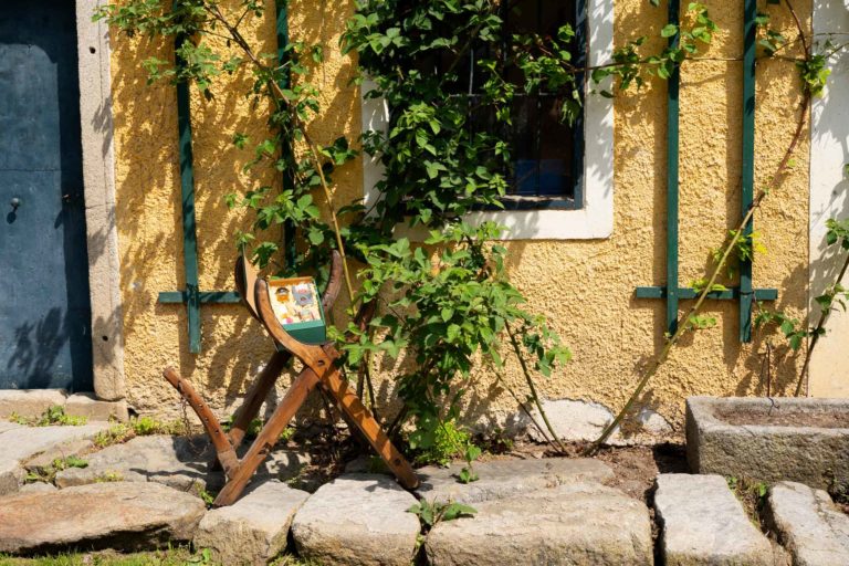 Geschenkbox drapiert vor einem Bauernhaus